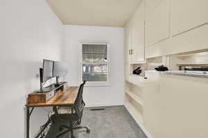 Office with light colored carpet and baseboards