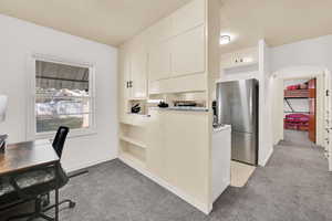 Office area with light carpet and arched walkways