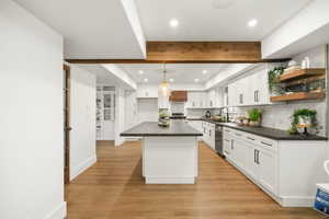 Gorgeous updated kitchen with white cabinets,  stunning solid surface countertops, stainless steel appliances and beautiful pendant lighting .