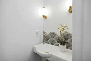 Main floor 1/2 bath with penny tile flooring and updated sink and lighting