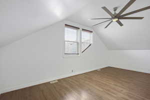 Bedroom with walk in closet, wood-look flooring and a ceiling fan