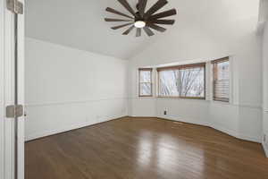 Primary bedroom with wood-look floors, ceiling fan, and tons of natural light
