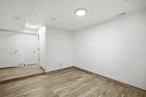 Basement bedroom with large walk in closet and wood-look flooring