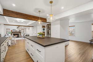 Gorgeous updated kitchen with white cabinets,  stunning solid surface countertops, stainless steel appliances and beautiful pendant lighting .