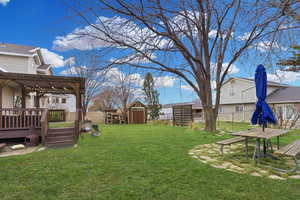 Fenced backyard featuring a chicken coop and storage shed