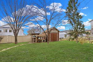 Fenced backyard featuring a storage shed