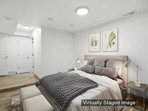 Basement bedroom with recessed lighting and wood-look floors