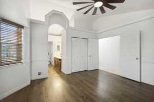 Primary bedroom with wood-look floors, ceiling fan, and tons of natural light.