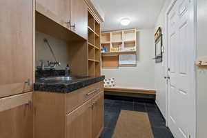 Mudroom featuring a sink and dark tile patterned flooring