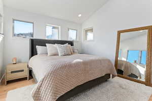 Bedroom featuring lofted ceiling, multiple windows, recessed lighting, and light wood finished floors