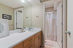 Full bathroom with vanity, curtained shower, and light tile patterned flooring