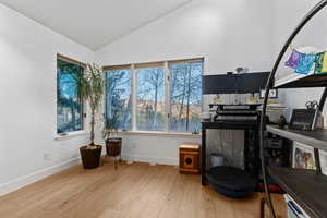 Office area featuring light wood-style flooring and lofted ceiling