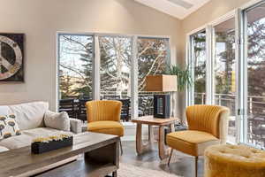 Sitting room with lofted ceiling, plenty of natural light, and tile patterned floors