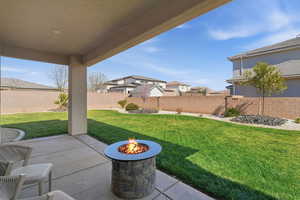 Fenced backyard with a patio area and a fire pit