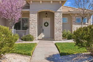 Property entrance featuring stucco siding and stone siding