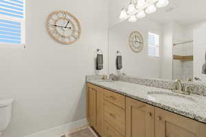 Full bath with double vanity and a shower