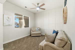 Living area with carpet floors and ceiling fan