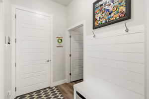 Mudroom featuring dark wood-style flooring and baseboards