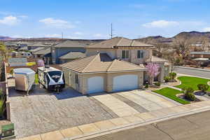 View of front of house featuring stone siding, stucco siding, concrete driveway, a mountain view, and a garage