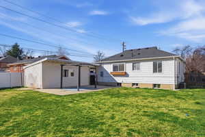Back of property featuring a fenced backyard, a patio area, and a shingled roof