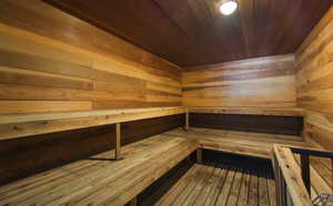 Relaxing sauna featuring wooden ceiling and wood walls