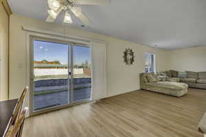 Living room with light wood-style flooring and a ceiling fan