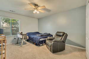 Bedroom featuring a ceiling fan and light colored carpet