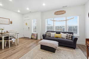 Living area with light wood-style flooring and recessed lighting