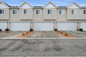 View of front of home with a residential view, a garage, and concrete driveway