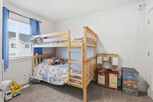 Bedroom featuring dark carpet and baseboards