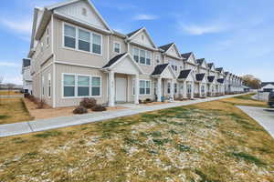 View of front of property featuring a front lawn, board and batten siding, and a residential view
