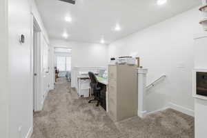 Home office with light carpet and recessed lighting