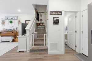Stairway with wood finished floors and baseboards