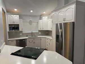Kitchen with stainless steel appliances, white cabinetry, recessed lighting, and backsplash