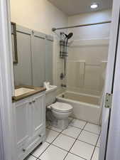 Bathroom with vanity, shower / bath combo with shower curtain, and light tile patterned floors