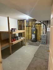 Unfinished below grade area with heating unit and water heater