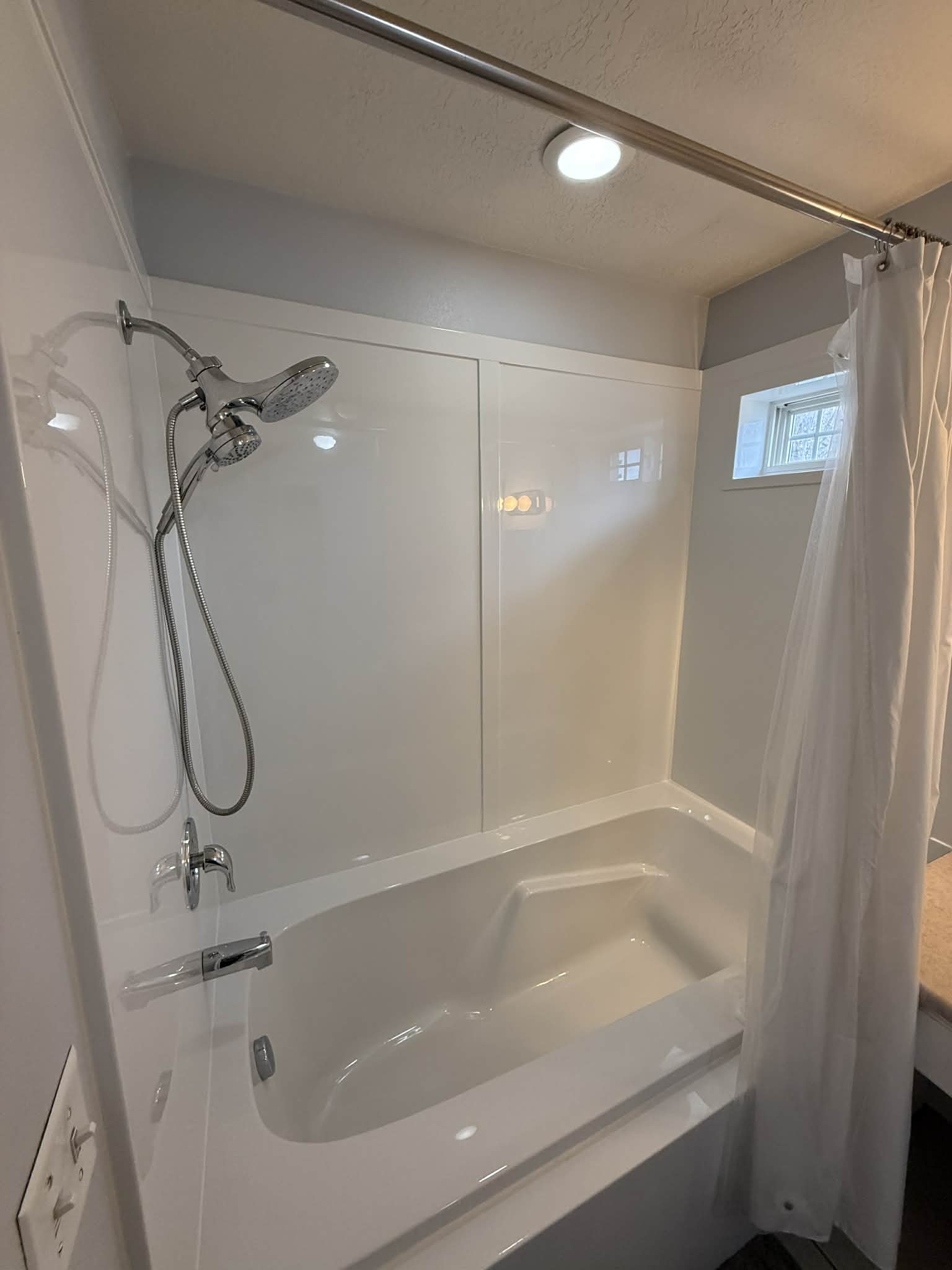 Bathroom with shower / bathtub combination with curtain and a textured ceiling