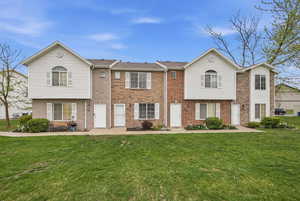 View of front of house featuring brick siding and a front lawn