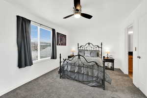 Carpeted bedroom with ceiling fan and baseboards