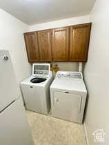 Laundry area with cabinet space and washer and clothes dryer