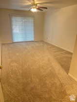 Empty room with carpet flooring and ceiling fan