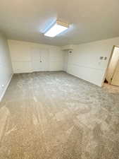 Bonus room with light carpet and a textured ceiling