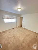 Unfurnished bedroom with carpet and a textured ceiling