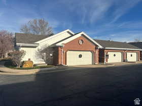 Ranch-style house featuring an attached garage, driveway, and brick siding