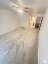 Carpeted empty room featuring a ceiling fan