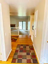 Hall with light wood-type flooring and an upstairs landing