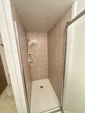 Full bath featuring toilet and a stall shower