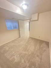 Unfurnished bedroom with a textured ceiling and carpet flooring