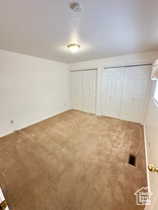 Unfurnished bedroom featuring carpet flooring and two closets