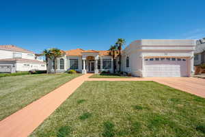 View of front of property featuring a garage, stucco siding, and a front lawn